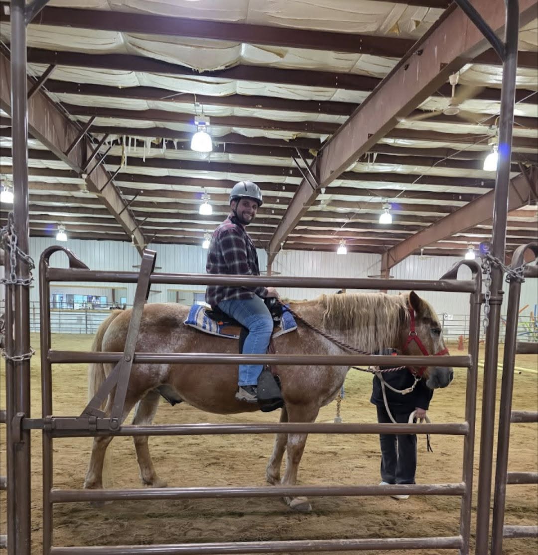 United Way's Executive Director, rides a horse named Tony at the Red River Riders facility