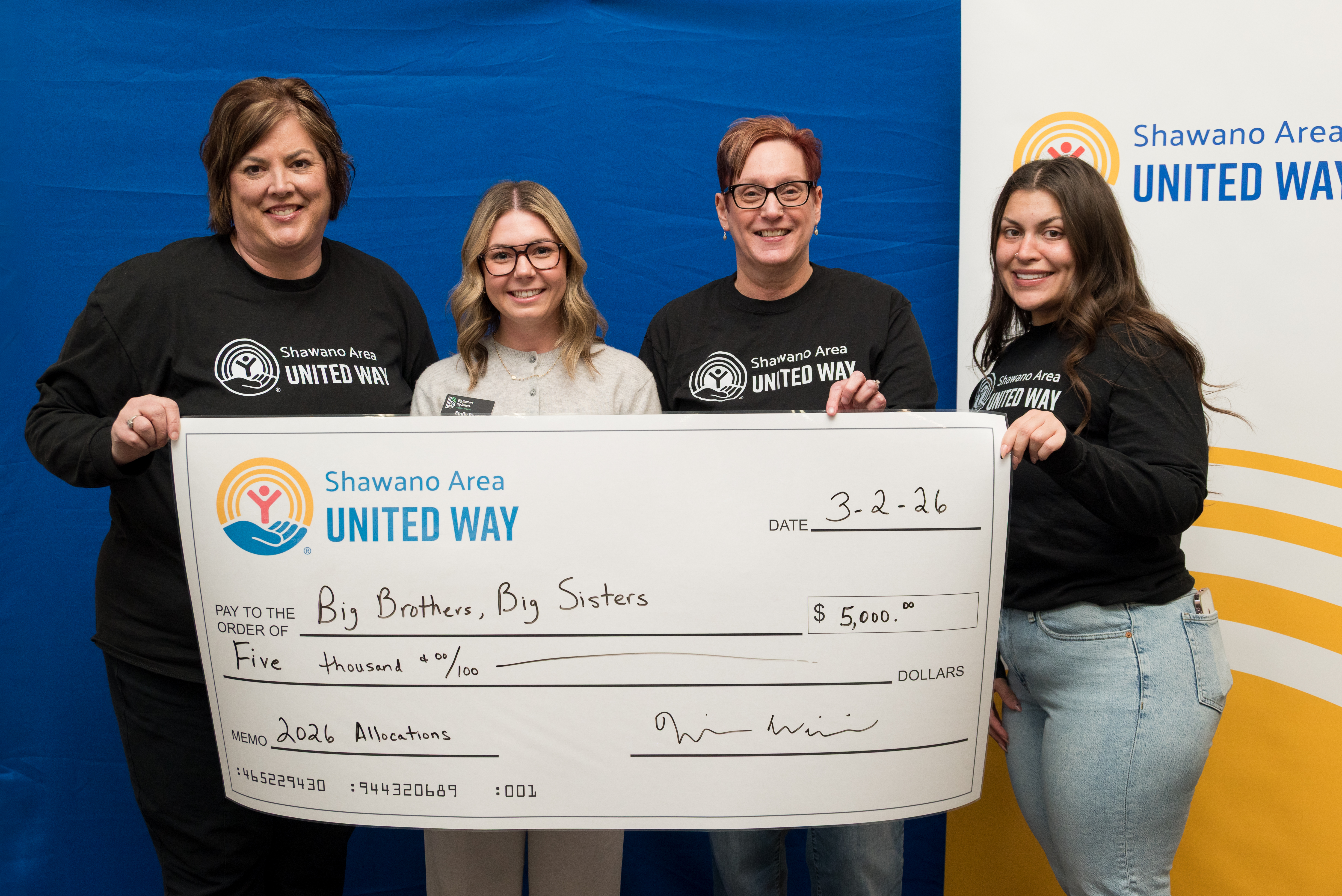 Check presentation to Big Brothers Big Sisters featuring Rhonda Strebel, Emily Burgess, Carol Sheier, and Maddie Priest